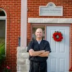 Dr. Lawson smiling outside the front door of the office